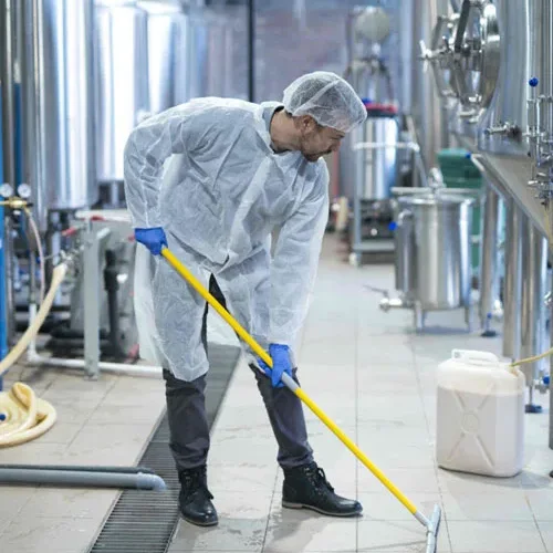 Worker mopping a stainless production kitchen floor