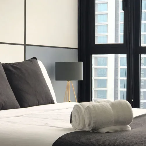 Freshly made hotel bed with rolled towels